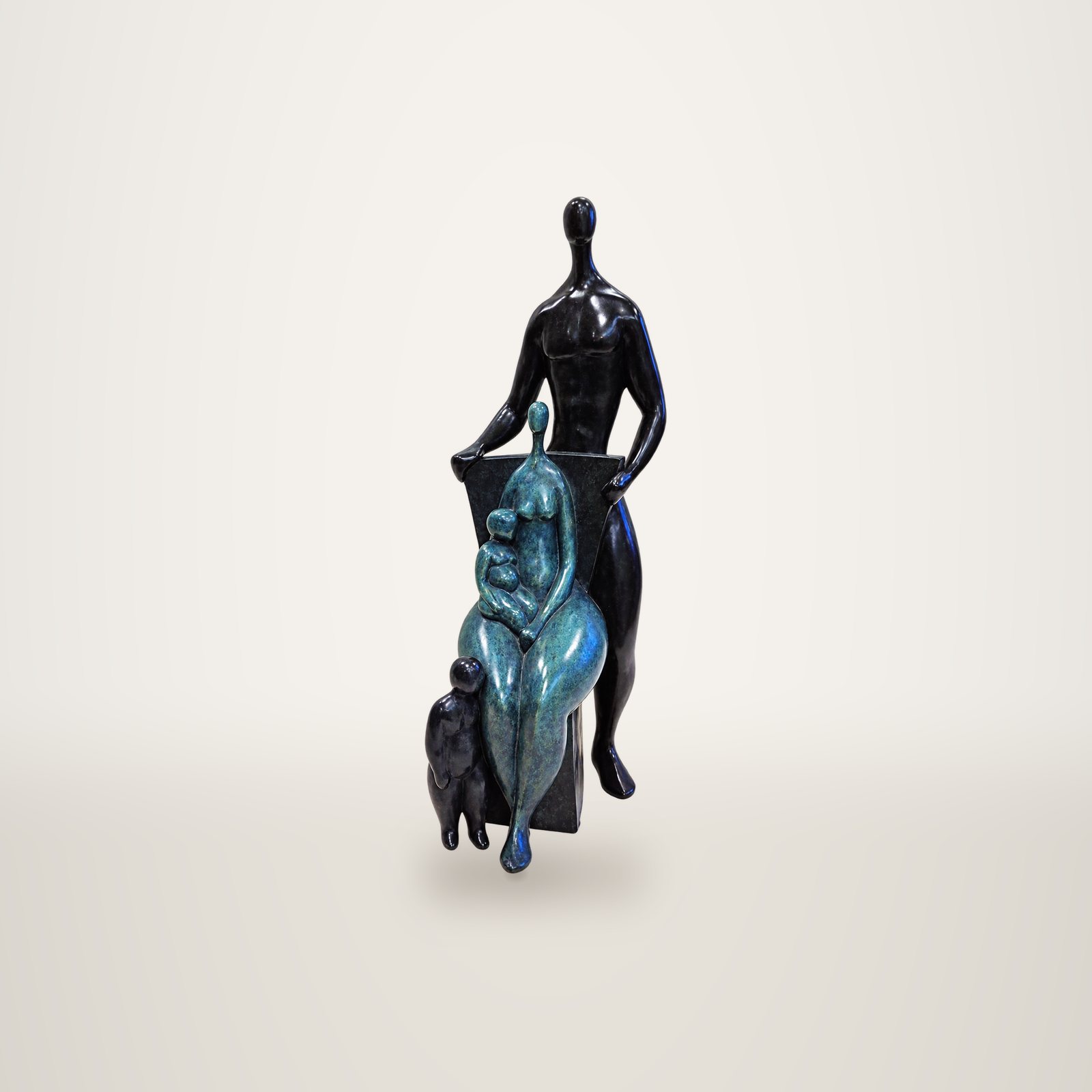 Sculpture en bronze représentant une famille stylisée : un homme debout en patine noire, une femme assise en patine verte tenant un bébé, et un enfant à leurs pieds.